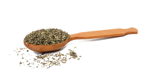 istock Crushed basil leaves in a brown wooden spoon 1419582493