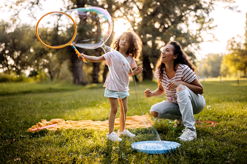 Two cute little kids, playing football together, summertime. Children playing soccer outdoor