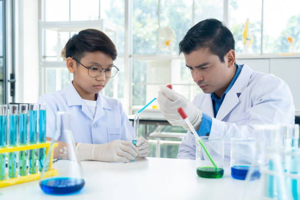istock Young teacher and student boy in science class at laboratory 1419585339