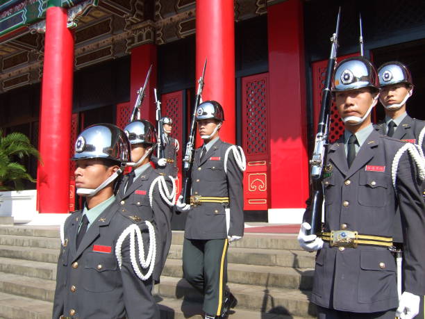 Taipei.Taiwan – Octorber 21, 2007:This is the Changing of the Guard of National Revolutionary Martyrs' Shrine in Taiwan.The changing of the guard ceremony takes place in the central square. Two guards stand at the main gate and main hall of Martyrs' Shrine.Soldiers that have been selected from the Army, Navy, Air Force will change once an hour.Soldiers who have passed strict conditions and undergone training do not move and do not change their facial expressions like dolls.The guards form a line of 5 people. Uniforms differ from army to army.Eligible to become a soldier are High school graduate or higher, no criminal record, height 175㎝ ~ 195㎝, weight 65kg ± 1kg.