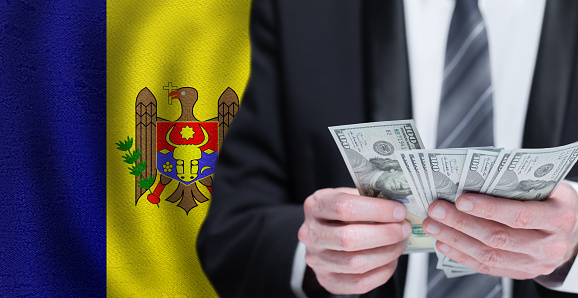 Hands holding dollar money on flag of Republica Moldova