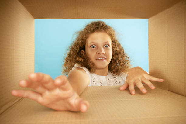 istock Take it. Happy smiling kid, little girl looking inside box during opening, unpacking it. Emotions, black friday, holidays, online shopping concept 1419588807