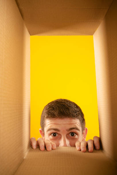 istock Pry into box. Charming man unpacking, opening carton box and looking inside with interest. Black friday, holidays, online shopping concept 1419588855