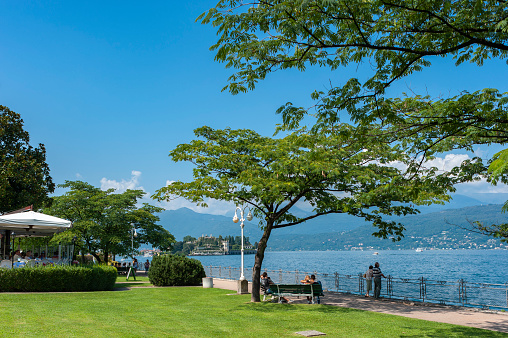 Stresa, Italy - August 15, 2018: Promenade in Stresa on Lake Maggiore, with Isola Bella in the background. Stresa is a town in Piedmont in northern Italy