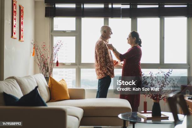 Chinese New Year An Indian Senior Couple Dresses Up For The Chinese New Year In Preparation For Reunion With Their Sons Multi Racial Family Stock Photo - Download Image Now