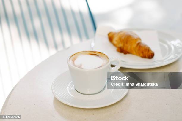Cup Of Cappuccino And A Croissant On A Table In A Street Cafe Selective Focus Stock Photo - Download Image Now