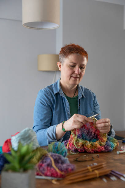 istock Mature Woman Learning Knitting Wool Through Laptop at Home 1419593278