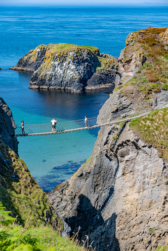 A man taking a photo on the Carrick-a-Rede rope bridge in County Antrim, Northern Ireland