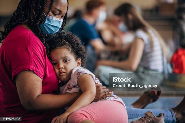 Mother And Child In Shelter After Natural Disaster Stock Photo - Download Image Now - Homelessness, Emergency Shelter, Coronavirus