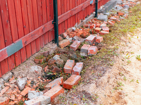 crushed bricks dropped under the fence for extra strengthening, outdoor shot