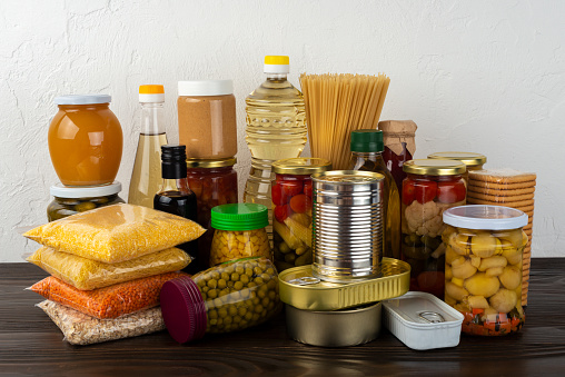 Emergency survival food set on dark wooden kitchen table