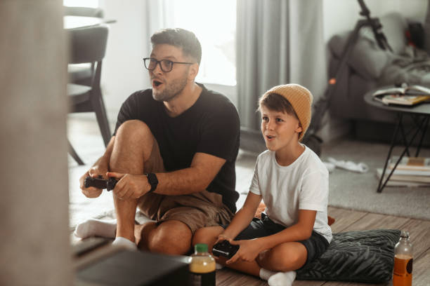 istock Father and son playing video games at home 1419607199