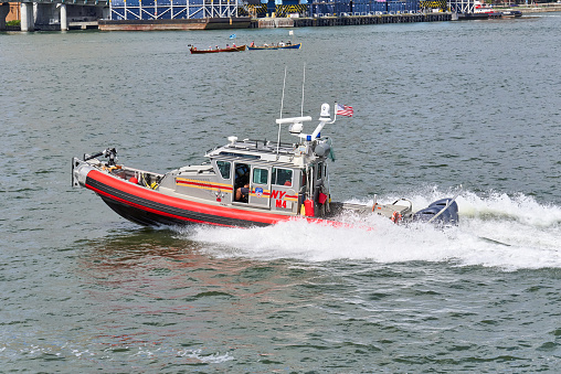New York, NY - August 13, 2022: A FDNY Fire Department patrol boat on the East River near 92nd St in Manhattan, NYC. This 33 foot full-cabin fire boat has a firefighting nozzle and pump in the bow.