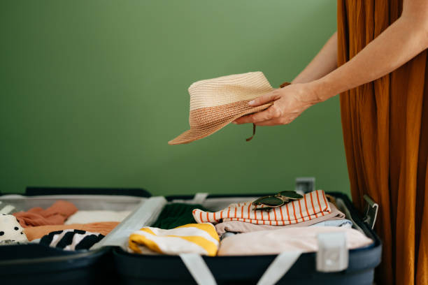 istock Anonymous Woman Putting a Hat in Her Suitcase 1419610185