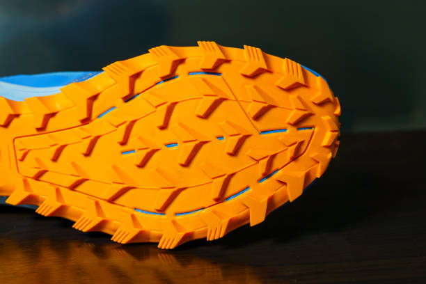 Shoes are placed on a reflective surface, Orange tread soles for trail running. The sole is very thick for wading on smooth roads and muddy roads. Shoes are placed on a reflective surface, Orange tread soles for trail running. The sole is very thick for wading on smooth roads and muddy roads. grooved stock pictures, royalty-free photos & images