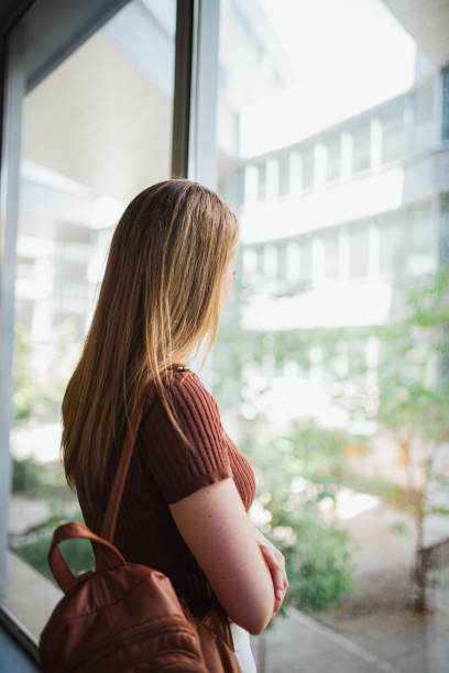 istock Student girl looking through the window during a class break 1419611156