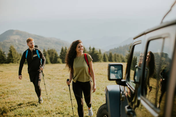 istock Smiling couple walking with backpacks over green hills 1419611458