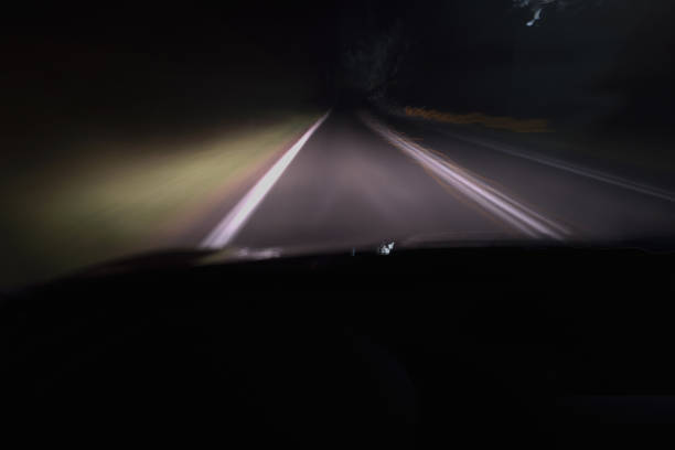 conduite nocturne floue sur une route sombre - asphalt two lane highway natural phenomenon fog photos et images de collection