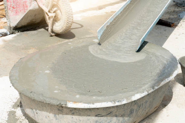 Liquid cement water in the mortar mixing tank. flowing down from the plastic guide rail. stock photo