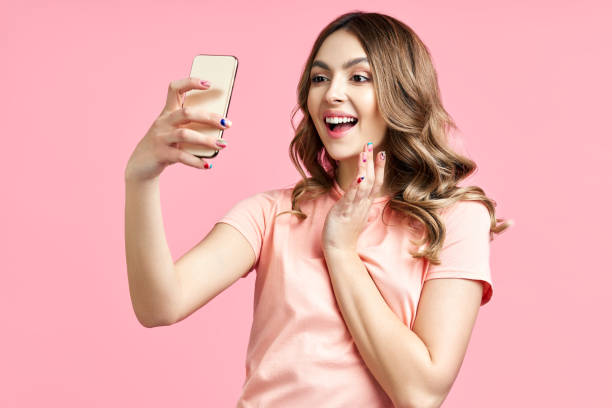 istock Young smiling woman making video call using mobile phone to communicate with friend 1419614204