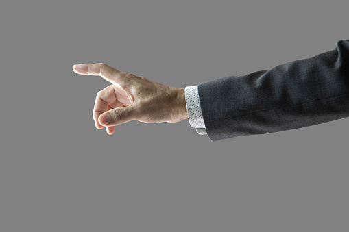 Right hand and forearm of a businessman with gray suit jacket sleeve with white shirt, pointing forward showing touching something gesture. Isolated on 50% gray. Clipping path included.
