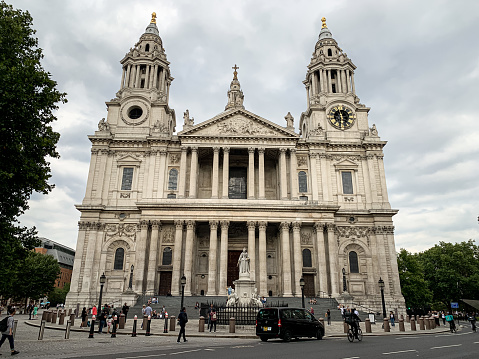 City of London, main Anglican Church building in London. St. Paul’s cathedral view from St. Paul's Churchyard. Summer in London. Cloudy sky. Front view
