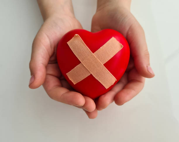 istock Wounded heart with band-aid in children hands 1419616351