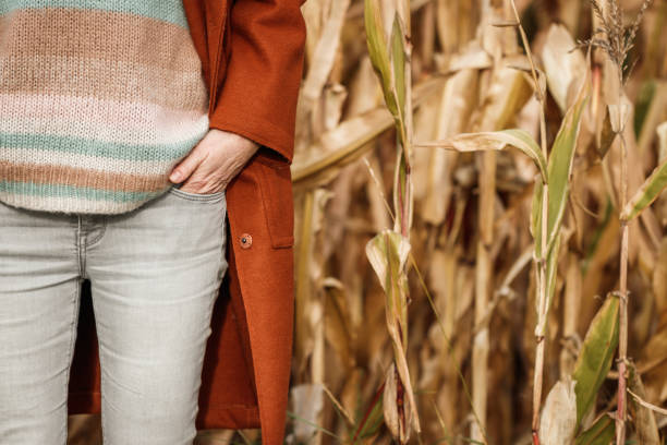 kobieta z czerwonym płaszczem, chudymi dżinsami i wełnianym swetrem z dzianiny - fashion women denim farm zdjęcia i obrazy z banku zdjęć