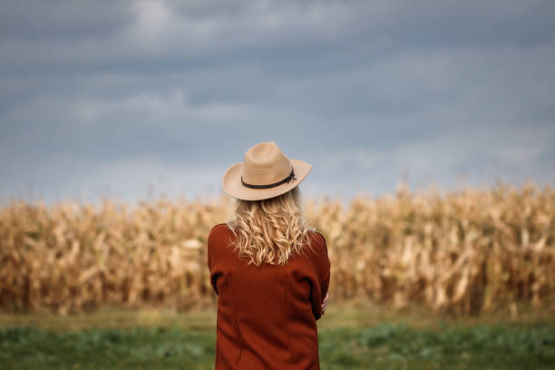 istock Woman with red coat and cowboy hat in corn field 1419618140