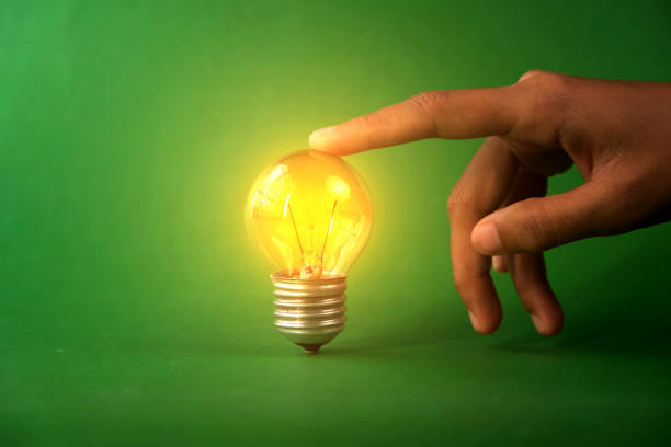 Human hand with light bulb shape on blue background.