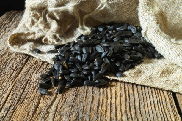 istock Sunflower seeds from a bag on a wooden table 1419618774