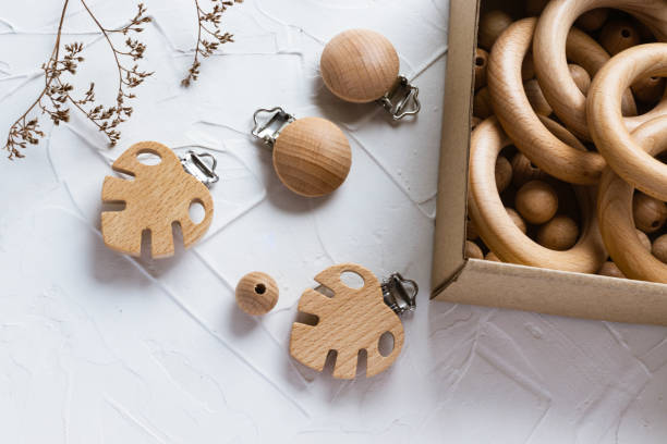istock Wooden rings and beads in craft box, monstera clips for baby teether on white background. Natural wood toy for child. Eco-friendly children toy. Handmade and hobby concept. Top view, flat lay. 1419619364