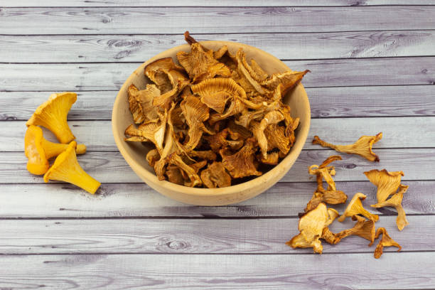 istock Dry chanterelles in wooden bowl on table 1419623714