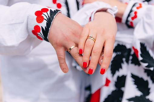 Close-up hands of newlyweds with wedding rings. engagement. embroidered clothes.