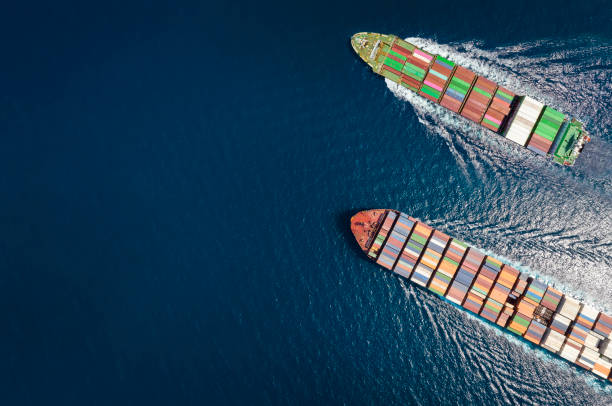 High aerial top down view of two container cargo ships traveling over open ocean High aerial top down view of two container cargo ships traveling over open ocean with copy space as a concept for import and export industry ship stock pictures, royalty-free photos & images