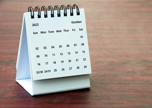 October 2022 calendar on wooden desk with customizable space for text or ideas. Copy space