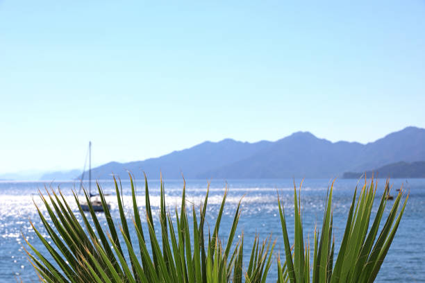View to sailboat in sea and mountains in mist