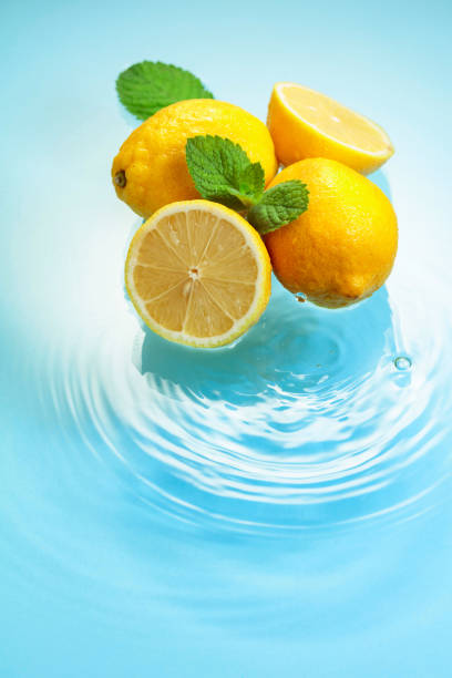 istock Juicy lemons with mint on a blue background with water splashes. 1419627627