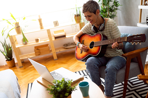 Woman taking online guitar lessons.