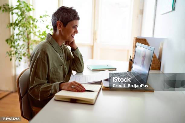 Woman Following Online Courses On Her Laptop At Home Stock Photo - Download Image Now