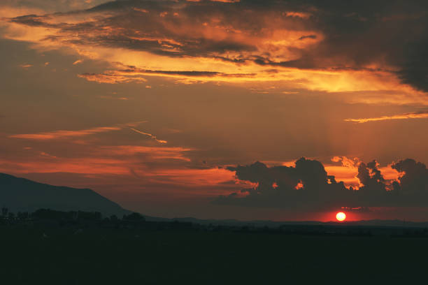 Silhouette of the clouds at sunset. Sky painted colored in red and orange