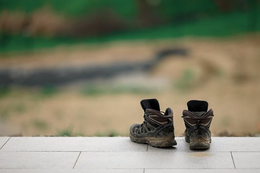 Close up picture of dirty hiking boots on a veranda