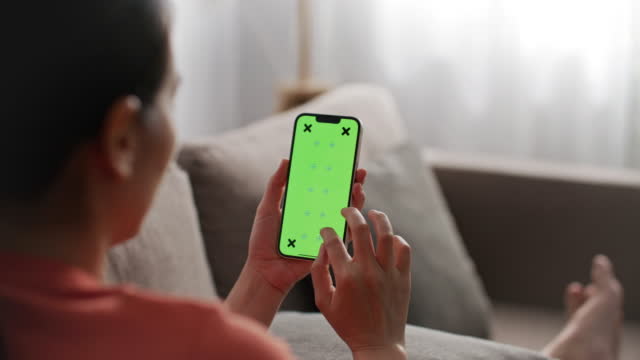 Woman using app on mobile with Chroma key on screen