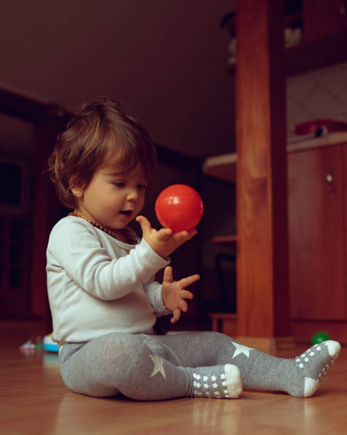 istock young adorable girl playing with a red ball 1419635205