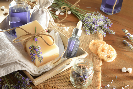 Detail of skin care products with lavender essence on wooden table. Elevated view.