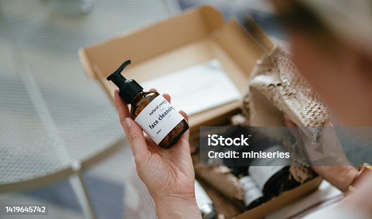 istock Anonymous Woman Holding a Gift Box and Looking at Beauty Cosmetics Products Inside (Copy Space) 1419645742