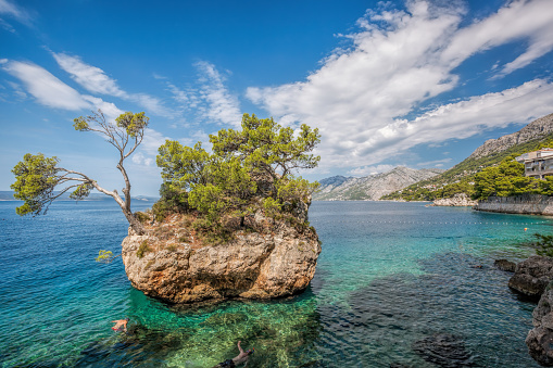 Punta Rata beach with stone island against sunset in Brela, Makarska, Dalmatia, Croatia