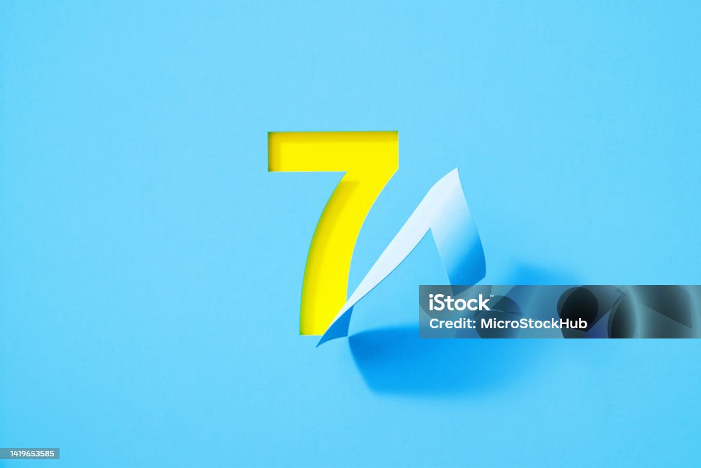 Blue Number Seven Folding on Yellow Background Blue number seven folding on yellow background. Horizontal composition with copy space. Number 7 Stock Photo