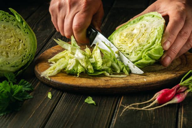 istock The chef cuts fresh cabbage with a knife on a cutting board before preparing a vegetarian dish 1419655858