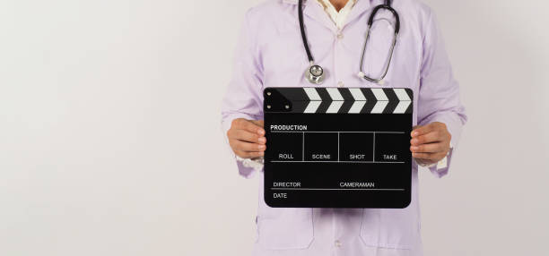 istock Doctor's holding Black Clapper board in hand on white background. Studio shooting. 1419657018